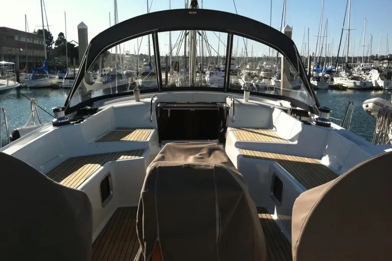 Slide: The Image of 2011 Jeanneau 57 yacht cockpit with teak seating, docked in a marina. - 10
