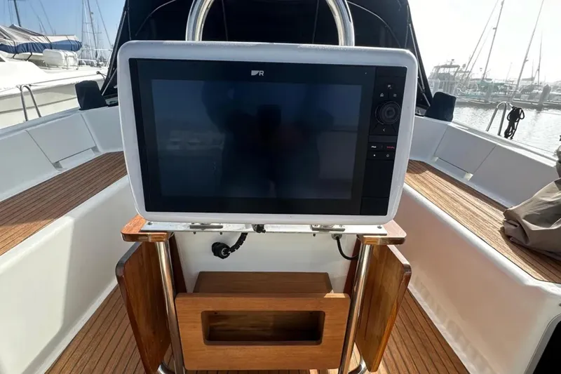 Slide: The Image of Cockpit of 2011 Jeanneau 57 yacht with navigation display and wooden seating. - 21