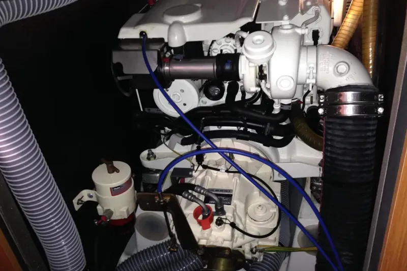 Slide: The Image of Engine compartment of a 2011 Jeanneau 57 sailboat, featuring hoses and mechanical components. - 52