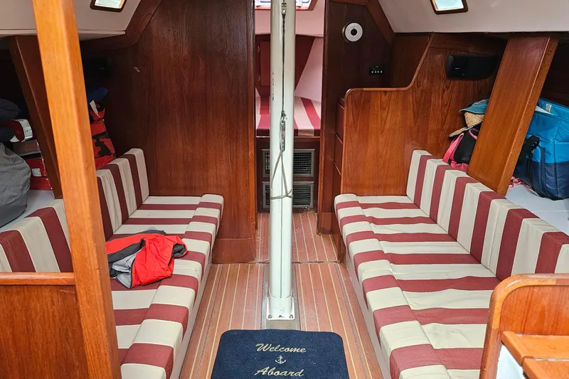 Slide: The Image of Interior of 1977 Peterson 34 Sloop with striped seating and wooden finishes. - 13