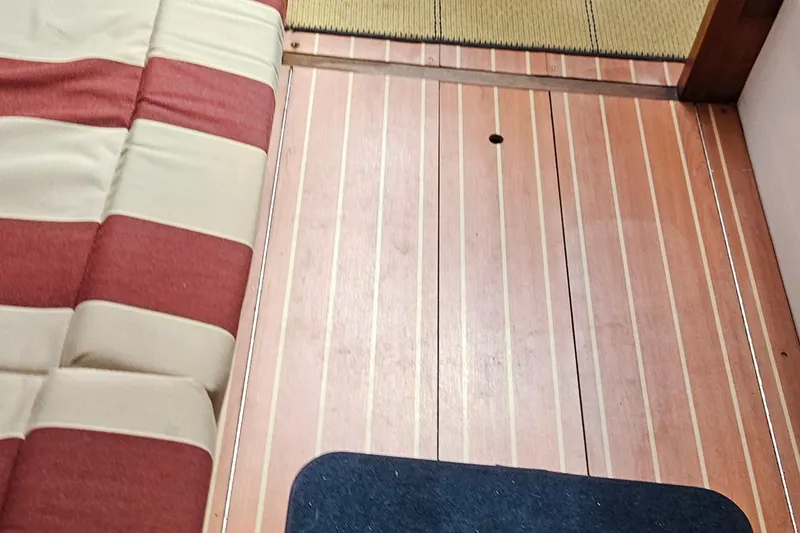 Slide: The Image of Interior of 1977 Peterson 34 Sloop with striped upholstery and wooden flooring. - 15