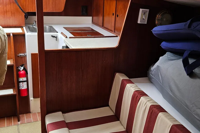 Slide: The Image of Interior of 1977 Peterson 34 Sloop with striped seating and compact kitchen area. - 17