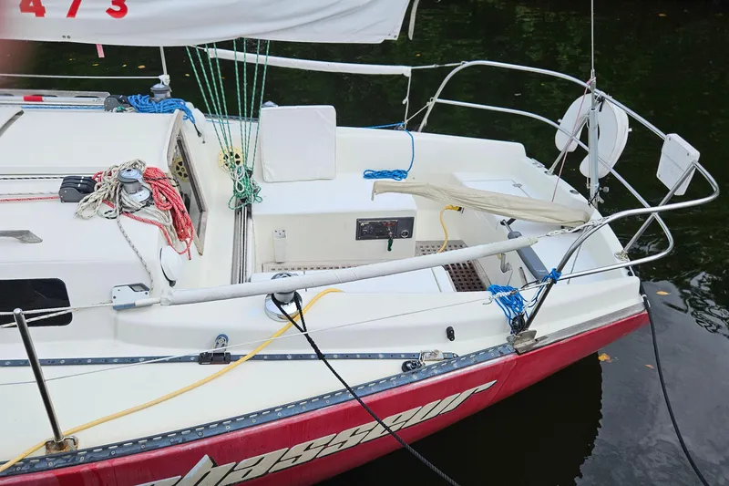 Slide: The Image of 1977 Peterson 34 Sloop sailboat with red hull, docked, featuring ropes and deck equipment. - 2
