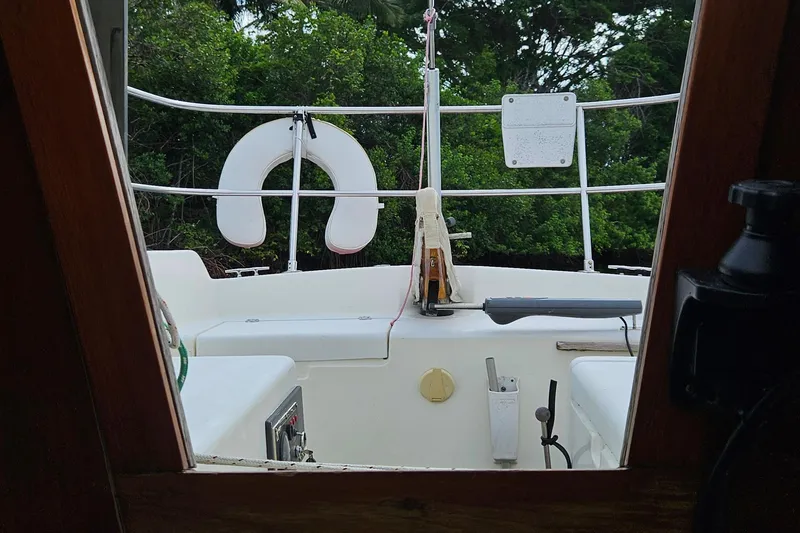 Slide: The Image of Interior view of a 1977 Peterson 34 Sloop sailboat, featuring cockpit and lush greenery. - 22