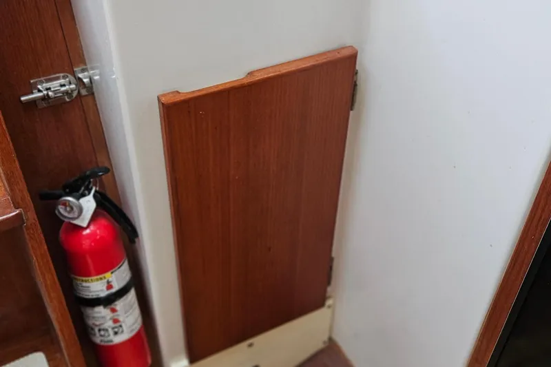 Slide: The Image of Fire extinguisher and wooden panel inside 1977 Peterson 34 Sloop sailboat. - 25