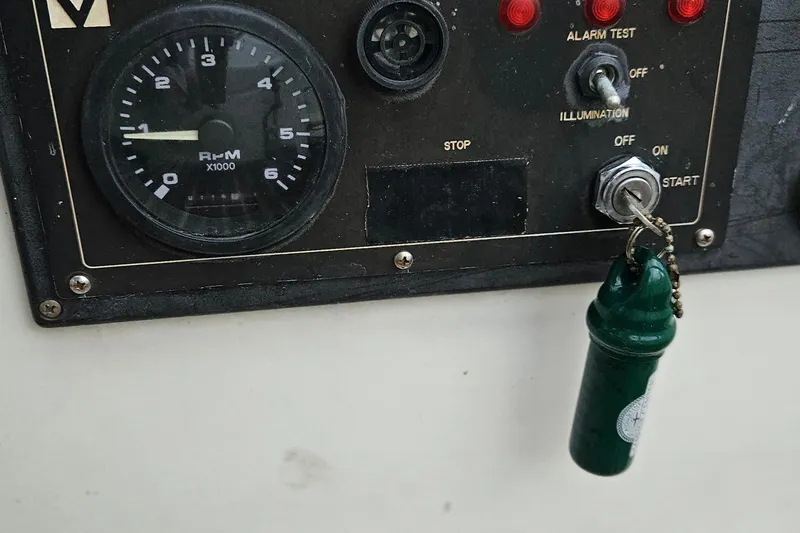 Slide: The Image of Control panel of a 1977 Peterson 34 Sloop with RPM gauge and ignition key. - 36