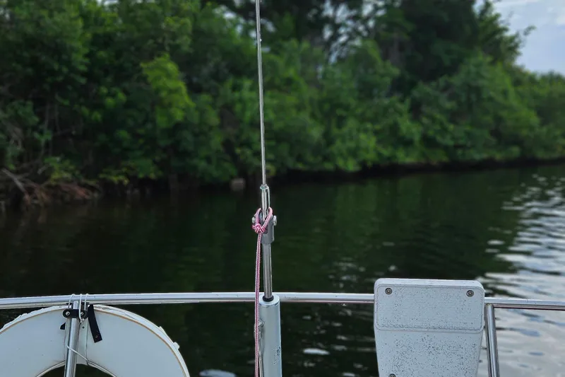 Slide: The Image of 1977 Peterson 34 Sloop sailboat with life ring, calm water, and lush greenery. - 39