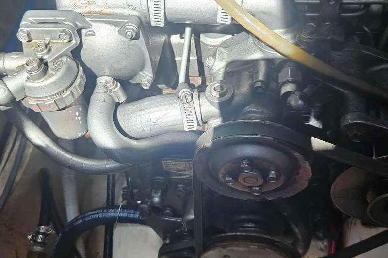 Slide: The Image of Engine components of a 1977 Peterson 34 Sloop, showcasing belts and hoses. - 42