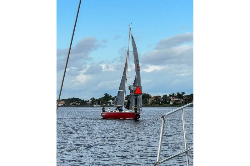 Slide: The Image of Red Peterson 34 Sloop sailboat from 1977 on calm waters under a cloudy sky. - 48