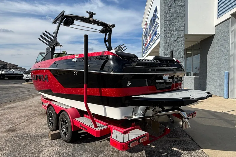 Slide: The Image of 2019 Supra SL 450 boat with red and black design on a trailer outside a dealership. - 4