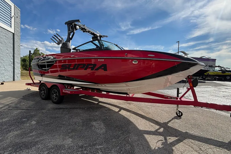 Slide: The Image of 2019 Supra SL 450 boat on trailer, vibrant red and black design under clear sky. - 50