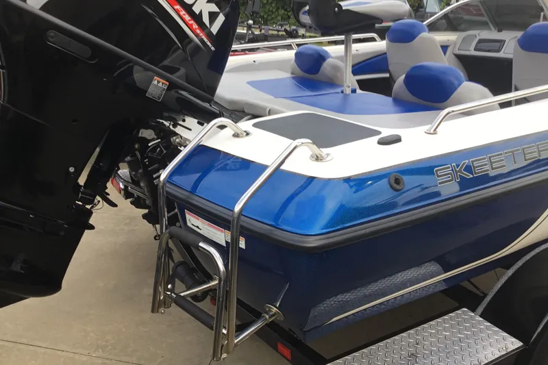 Slide: The Image of 2011 Skeeter SL190 boat with Suzuki outboard motor, blue and white design, rear view. - 10