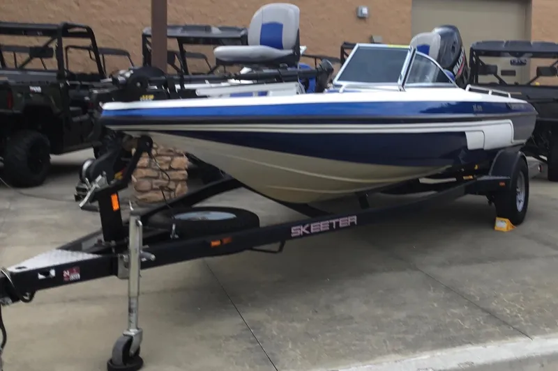 Slide: The Image of 2011 Skeeter SL190 boat on trailer, parked outdoors. - 2
