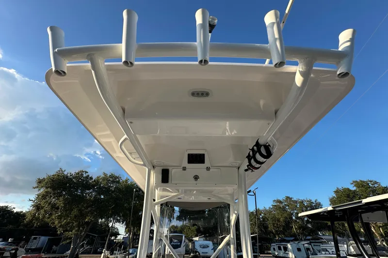 Slide: The Image of 2022 Sea Fox 228 Commander boat with T-top and rod holders under clear blue sky. - 22