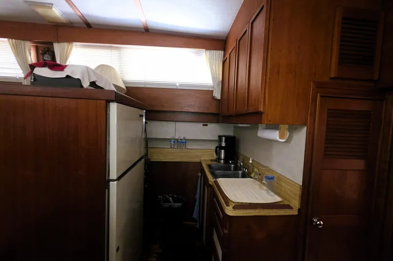 Slide: The Image of 1979 Trojan 44 Motor Yacht kitchen with wood cabinets, sink, and refrigerator. - 10