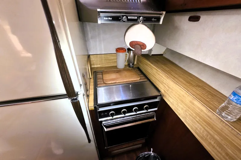 Slide: The Image of 1979 Trojan 44 Motor Yacht kitchen with stove, cutting board, and refrigerator. - 11