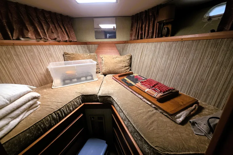 Slide: The Image of Cozy cabin interior of 1979 Trojan 44 Motor Yacht with bedding and storage. - 12