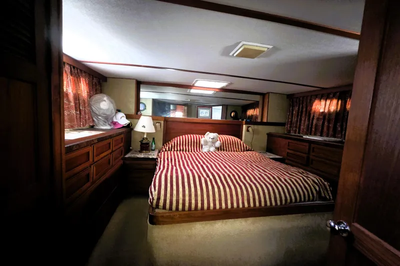 Slide: The Image of Cozy bedroom in 1979 Trojan 44 Motor Yacht with striped bedding and wooden cabinetry. - 14