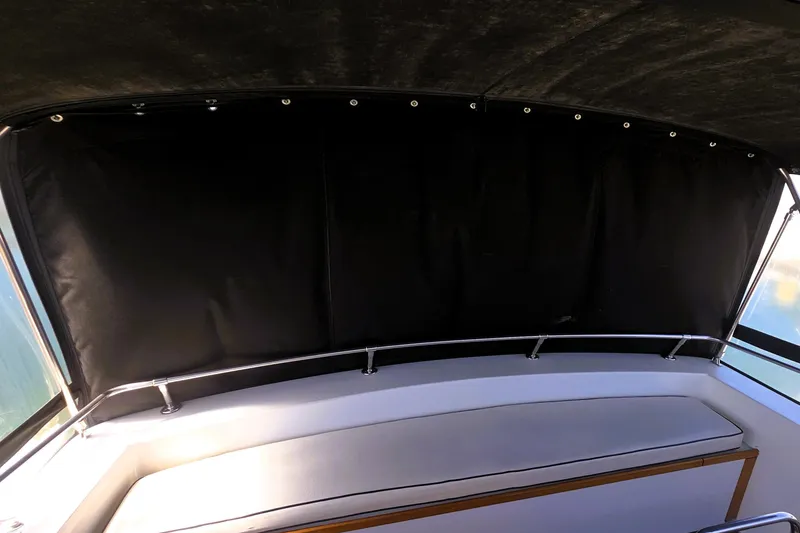 Slide: The Image of 1979 Trojan 44 Motor Yacht interior with cushioned seating and black canopy. - 19