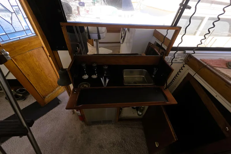 Slide: The Image of 1979 Trojan 44 Motor Yacht interior with compact bar and sink setup. - 2