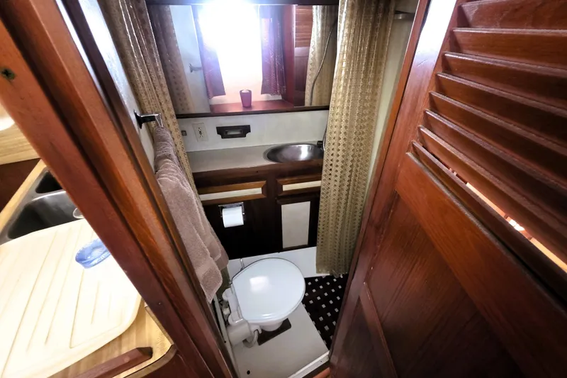 Slide: The Image of 1979 Trojan 44 Motor Yacht bathroom with wooden accents and compact design. - 21