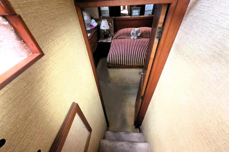 Slide: The Image of Interior of 1979 Trojan 44 Motor Yacht with cozy bedroom and striped bedding. - 23