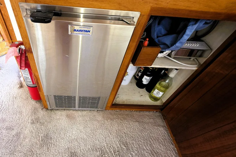 Slide: The Image of 1979 Trojan 44 Motor Yacht interior with Raritan fridge and storage shelves. - 3