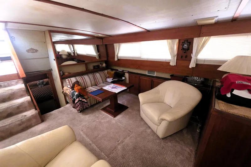 Slide: The Image of Interior of 1979 Trojan 44 Motor Yacht with cozy seating and wooden accents. - 5