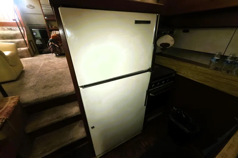 Slide: The Image of 1979 Trojan 44 Motor Yacht interior with refrigerator and kitchen area. - 9