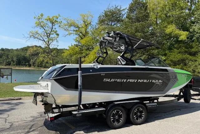 Slide: The Image of 2017 Nautique Super Air Nautique G23 boat on trailer by a lake. - 5