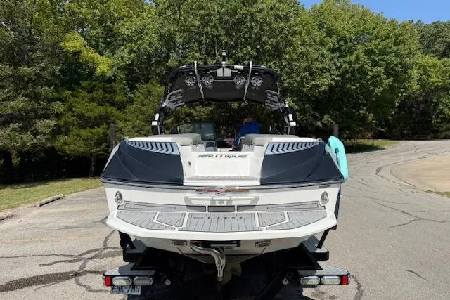 Slide: The Image of 2017 Nautique Super Air Nautique G23 boat on trailer, surrounded by trees. - 7