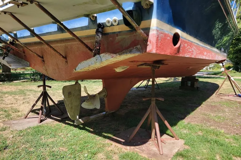 Slide: The Image of 1997 Albin 28 Tournament Express boat hull on stands, showing propeller and rudder. - 14