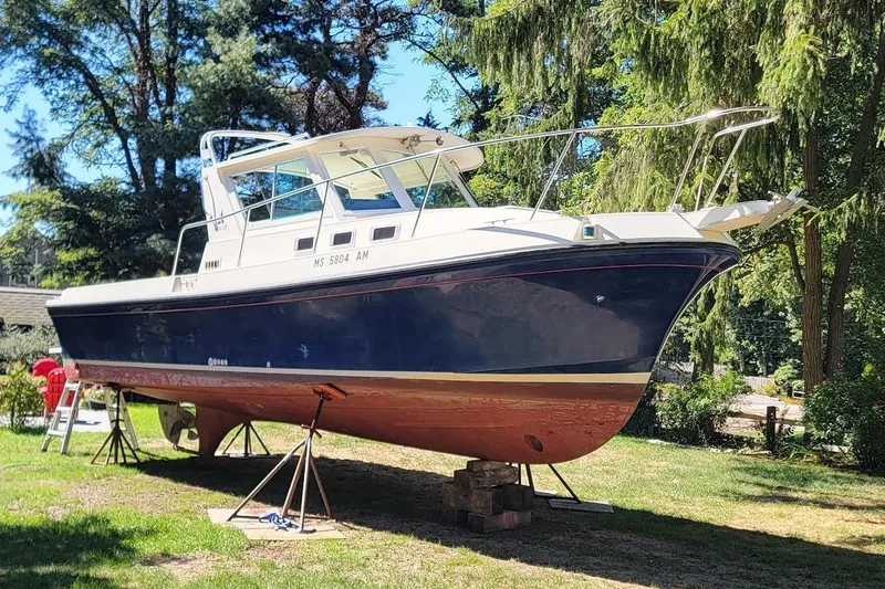 Slide: The Image of 1997 Albin 28 Tournament Express boat on stands in a wooded area. - 15