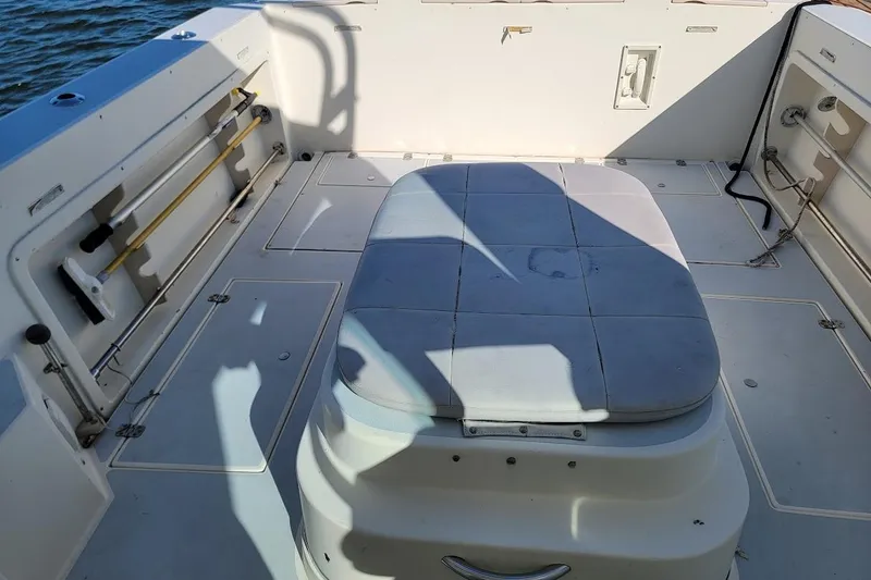 Slide: The Image of 1997 Albin 28 Tournament Express boat interior with cushioned seating and storage compartments. - 6