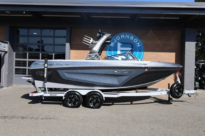 The Image of 2021 Tigé 21ZX boat on trailer outside dealership, showcasing sleek design and modern features. - 1
