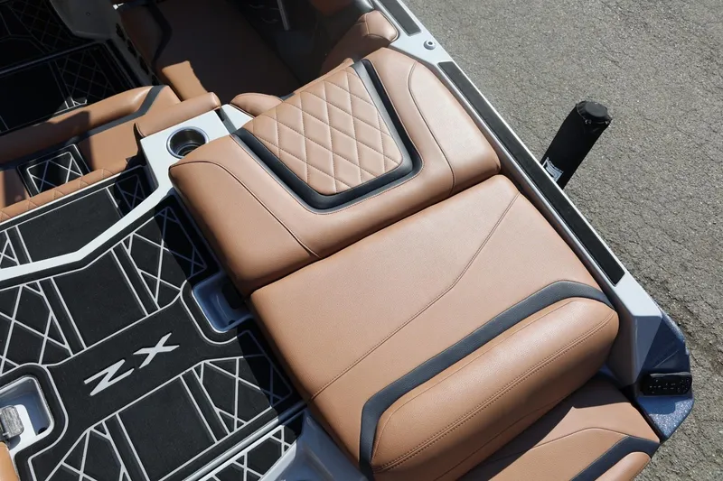 Slide: The Image of 2021 Tigé 21ZX boat interior with tan leather seats and stylish black flooring. - 10