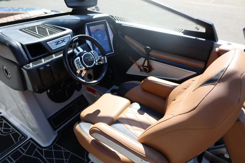 Slide: The Image of 2021 Tigé 21ZX boat interior with tan leather seat and modern dashboard controls. - 15