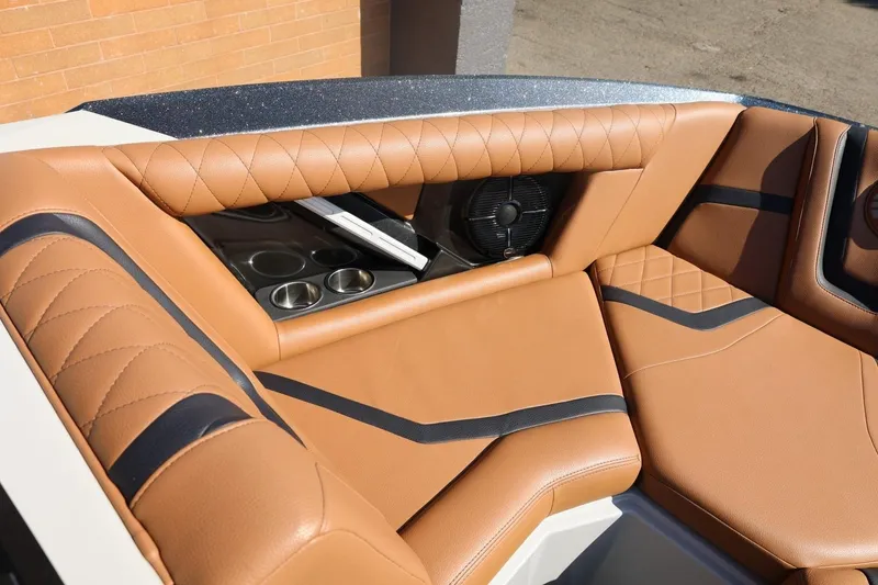 Slide: The Image of 2021 Tigé 21ZX boat interior with tan leather seats and cup holders. - 17