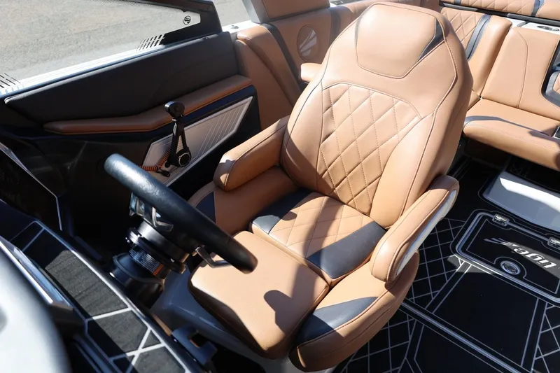 Slide: The Image of 2021 Tigé 21ZX boat interior with tan leather seats and modern steering wheel. - 24