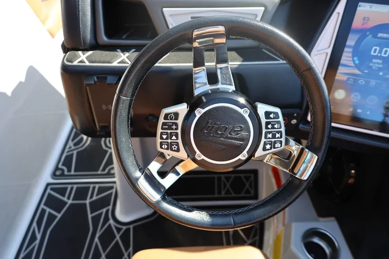 Slide: The Image of Steering wheel of 2021 Tigé 21ZX boat with control buttons and digital display. - 26