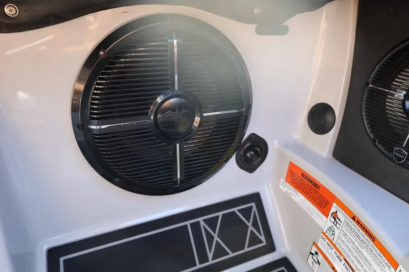 Slide: The Image of 2021 Tigé 21ZX boat interior speaker with warning labels and sleek design. - 36
