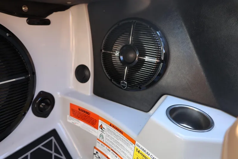 Slide: The Image of Interior of 2021 Tigé 21ZX boat featuring speakers and warning labels. - 37