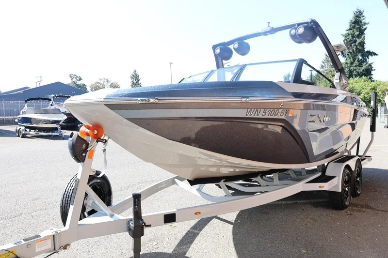 Slide: The Image of 2021 Tigé 21ZX boat on trailer, parked outdoors, showcasing sleek design and modern features. - 4