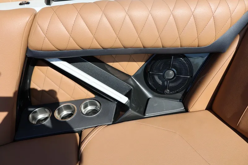 Slide: The Image of 2021 Tigé 21ZX boat interior with tan quilted seats, cup holders, and speaker. - 40