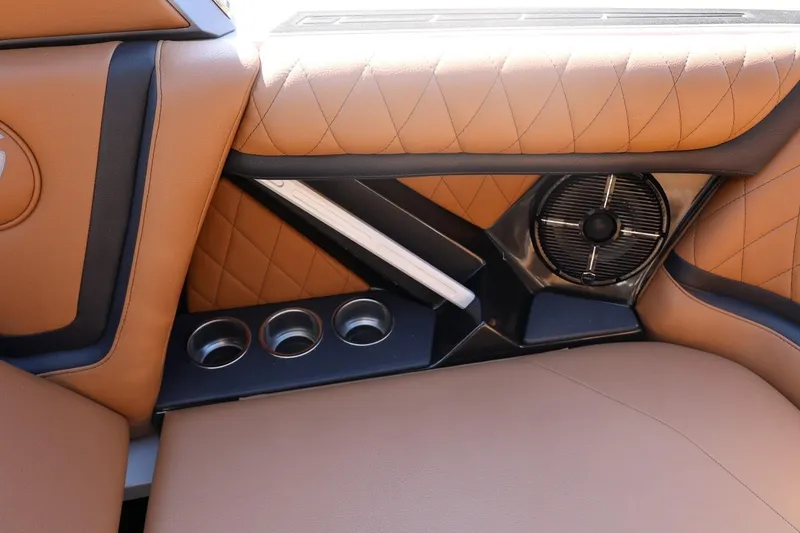 Slide: The Image of 2021 Tigé 21ZX interior with tan leather, cup holders, and speaker detail. - 42