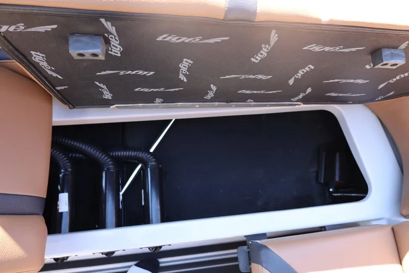 Slide: The Image of 2021 Tigé 21ZX boat storage compartment with tan upholstery and visible wiring. - 45