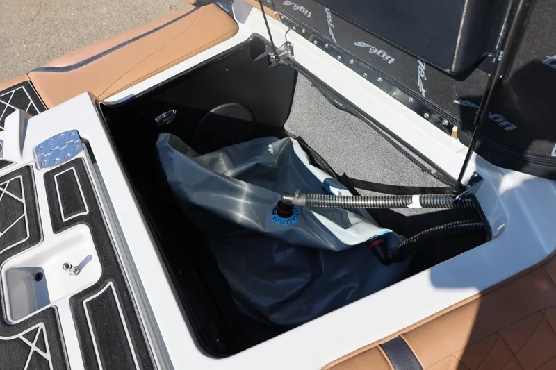 Slide: The Image of 2021 Tigé 21ZX boat storage compartment with ballast bag and hoses. - 48