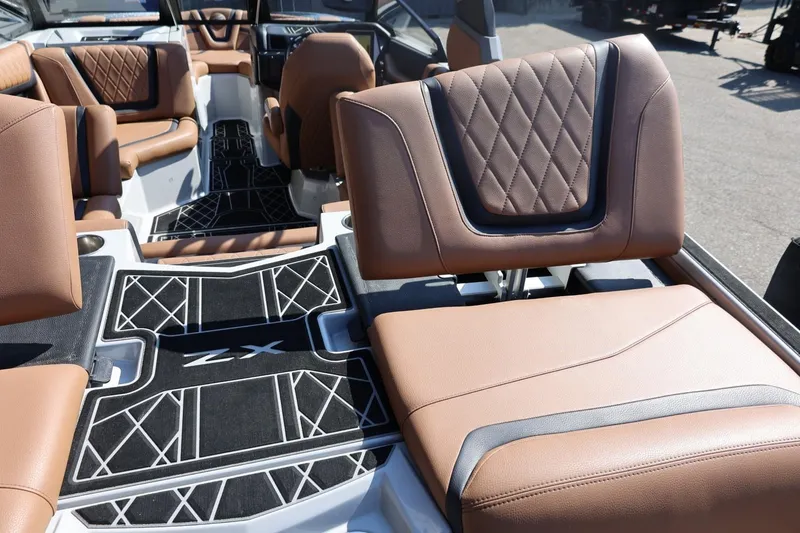Slide: The Image of 2021 Tigé 21ZX boat interior with brown leather seats and stylish black flooring. - 50
