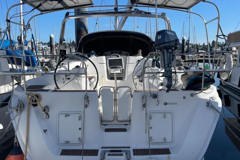 Slide: The Image of 2008 Hunter 49 sailboat docked, featuring dual steering wheels and Yamaha outboard motor. - 3