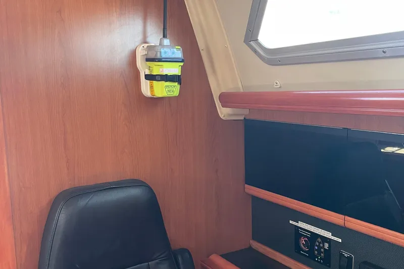 Slide: The Image of Interior of a 2008 Hunter 49 yacht with wooden paneling and navigation equipment. - 34